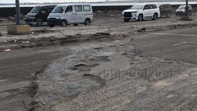 جزء متضرر بشدة من الطريق يعيق حركة السيارات ويتسبب بازدحامها
